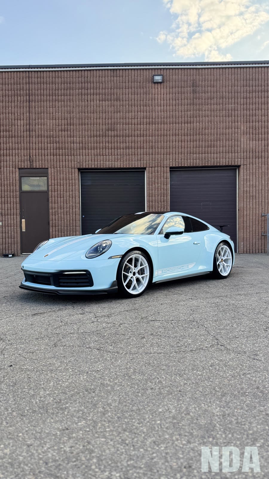 Gulf blue Porsche 911 Carrera on white wheels in the NDA garage